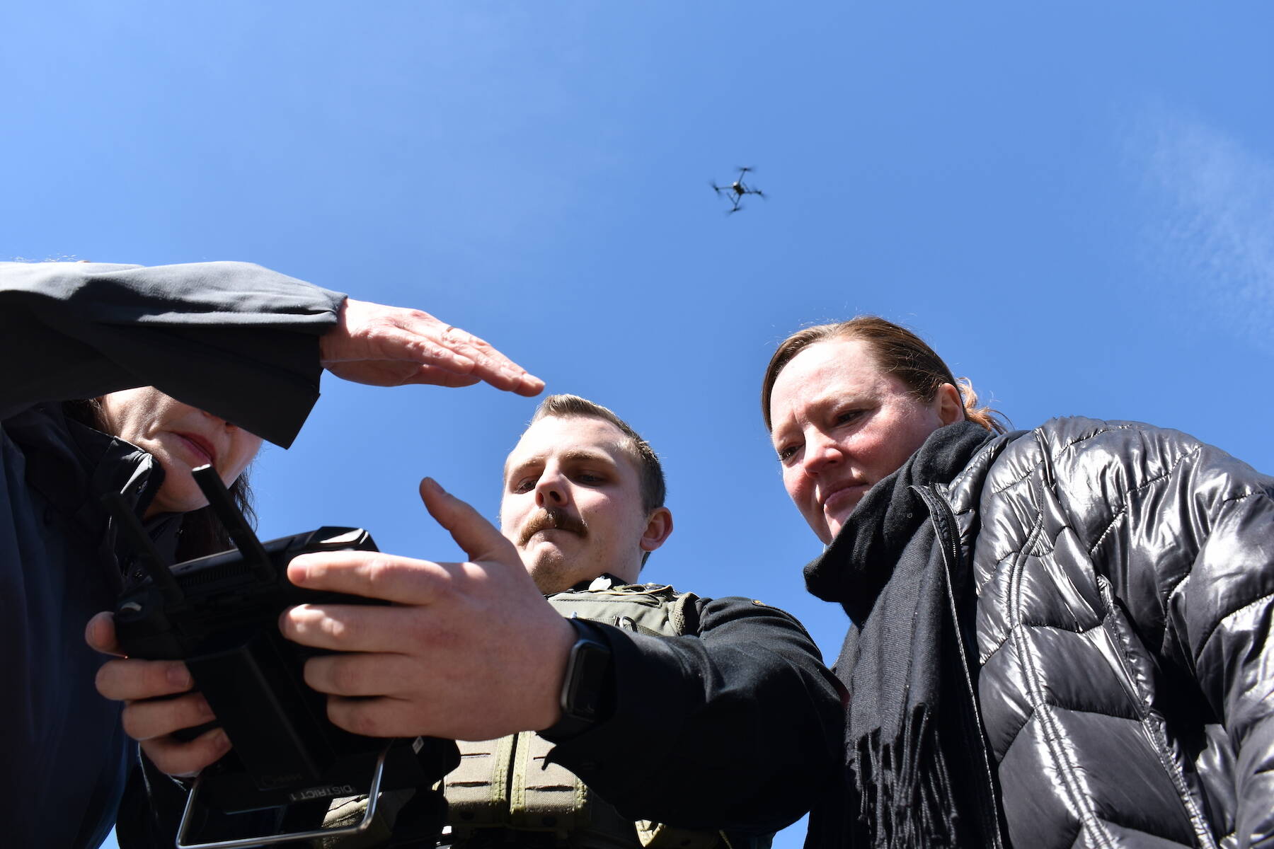 Kelley Balcomb-Bartok / Staff photo
San Juan County Sheriff Deputy Isaac Norton flies the department’s new drone as San Juan County Council members Jane Fuller (left) and Christine Minney (right) watch through the drone’s handheld monitor.