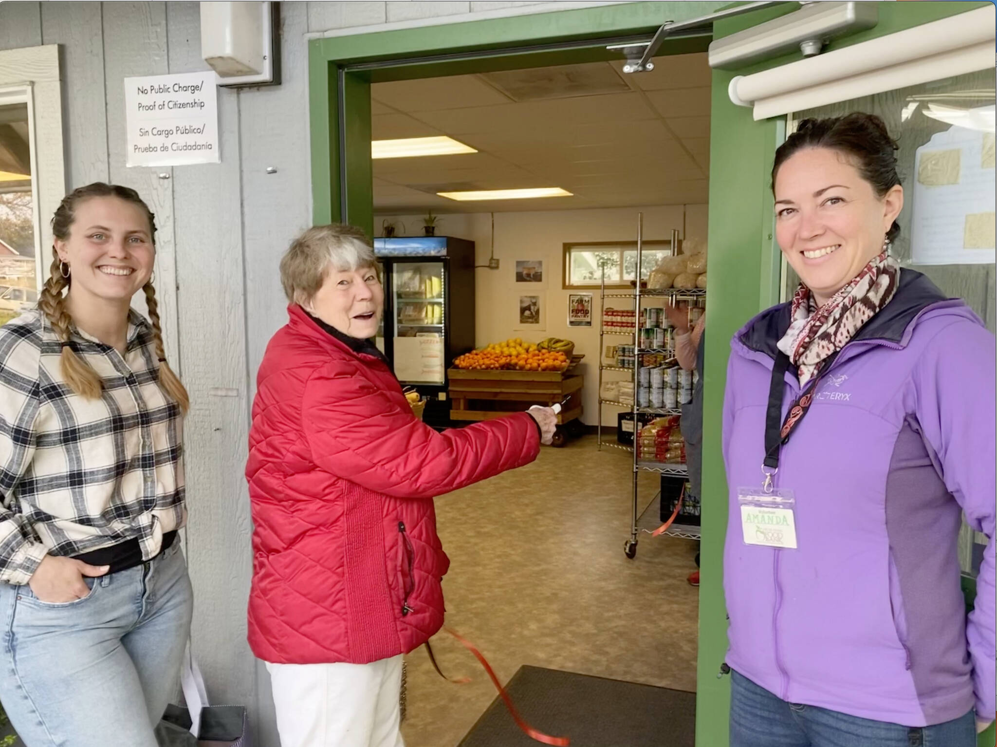 Rick Rhodes photo.
Carolyn Carroll cuts the ribbon and becomes the first customer to experience full self-service at the Orcas Island Food Bank with (left) Operations Manager Alison O’Toole and Executive Director Amanda Sparks (right).