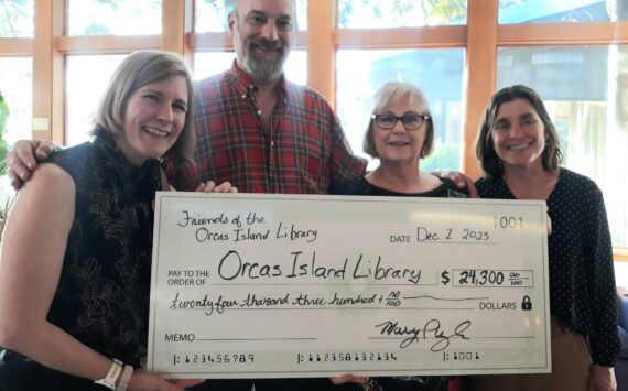 FOIL Board Members Michael Armenia, Mary Pugh, and Kathy Morris present the library director Ingrid Mattson (far left) with a check for books and programs for 2024.