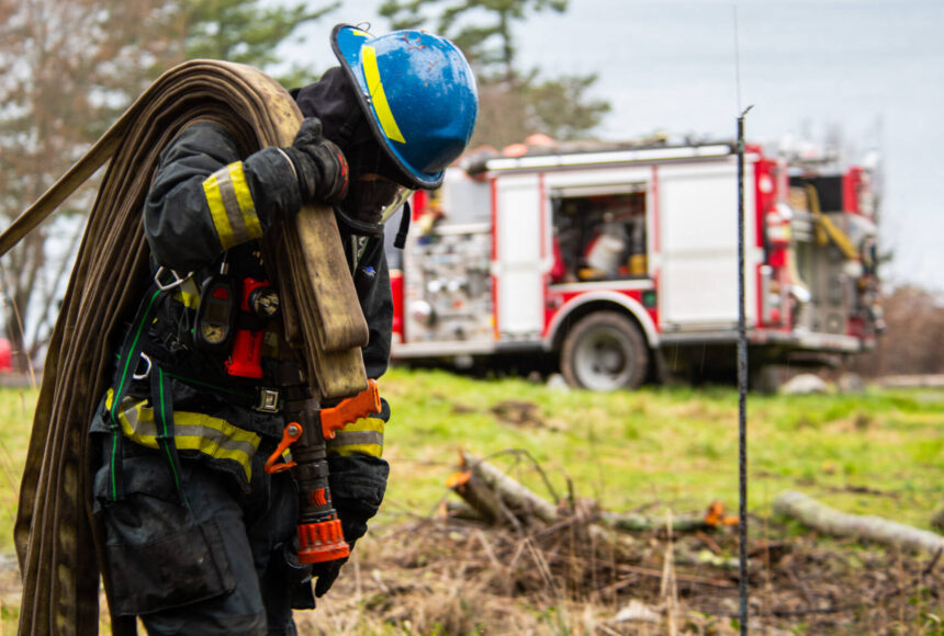 <p>A firefighter recruit pulling deploying hose at live fire training in February.</p>