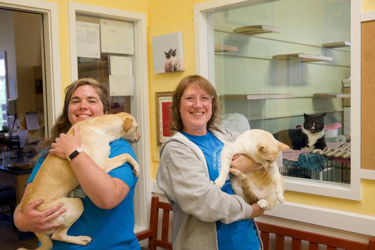 Darrell Kirk photo.
APS staff member Cheryl Stebbins with her dog Mango (adopted from the shelter) and Executive Director Kristina Snyder with Daphne, who is available for adoption.