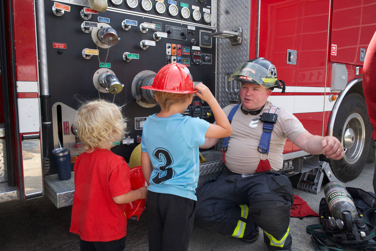 Darrell Kirk photo.
Firefighter Buddy Wright entertains two future firefighters.