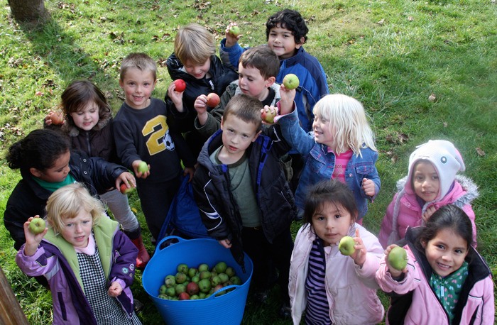 Orcas Montessori School kids show off their haul of organic apples.