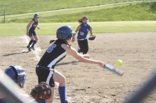 Emily Bodenhamer bunts for a single and  a run in over home plate.