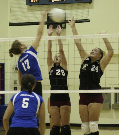 The Lady Lobos reach to block a Lady Viking's shot.