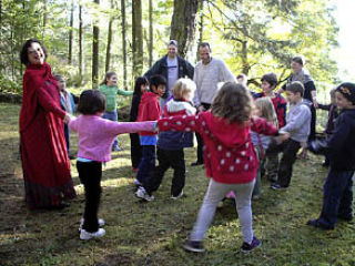 Antoinette Botsford leads Orcas Island first-graders in Ring-around-the-Rosy.