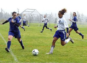 Stephanie Shaw charges the ball as Grace Hansen