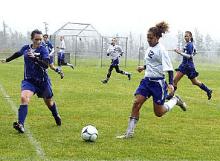 Stephanie Shaw charges the ball as Grace Hansen