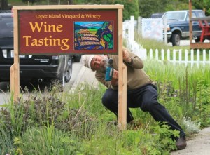 Brent Charnley putting up the sign for the new tasting room.