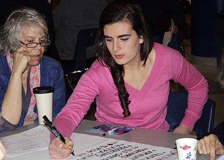 High school senior Lanie Padbury taking notes during the community potluck on March 10.