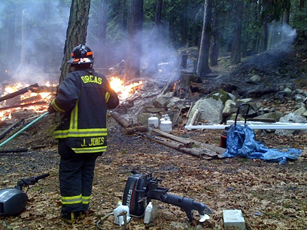 Lt. Jeff Jones cools venting propane bottles to prevent explosion.