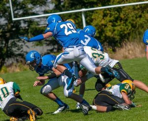 Devon Stanzione (29) leaping over Pirate defenders on his way to a first down.