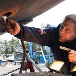 Staff photo/Hayley Day                                Josh Compton repairs the hull of a boat at Albert Jensen and Sons Boat Yard and Marina on SanJuan Island. Compton has worked for the shipyard for six months, after moving on island from Everett.