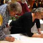Staff photo/Hayley Day                                Party attendees write greetings to the retiring judge.