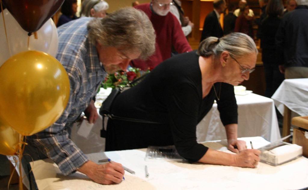 Staff photo/Hayley Day                                Party attendees write greetings to the retiring judge.