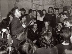 Pete Seeger entertaining Eleanor Roosevelt (center), honored guest at a racially integrated Valentines Day party marking the opening of a Canteen of the United Federal Labor, CIO, in then-segregated Washington, D.C., 1944.