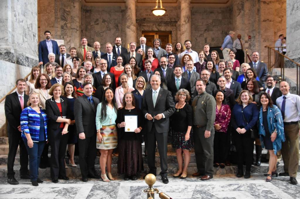 Supporters of the orca recovery bills stand for a photo after the governor signed the bills and read an orca proclamation. (Office of the Governor photo)