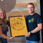 Heather Spaulding/staff photo                                At right: Executive Director Stephanie Buffum presented with a 569th plaque by Divemaster Thomas Kneipp.