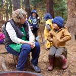 Amber Paulsen, Kaleidoscopes director, connects with forest school student Archer around the lunchtime campfire in the woods of Camp Orkila.