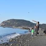 Raghu Maddirala of Bellevue and son Arjun, 3, throw rocks at West Beach in Deception Pass State Park last Saturday. The park would be used as a Navy training site along with others on Whidbey under a new five-year proposal. (Emily Gilbert/Whidbey News-Times)