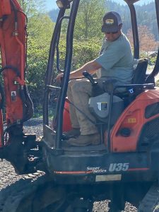 Contributed photo
Bathan Shaner levels the gravel bed for one of the food banks new shipping containers.