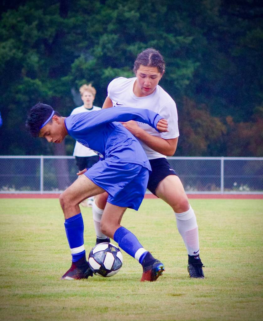 Corey Wiscomb photo
Whoever said soccer isnt a physical game probably hasnt played in an Orcas vs. Friday Harbor match! Here Pedro Banderas uses dominant position to shield the ball from a larger FH player before passing off to an open teammate.
