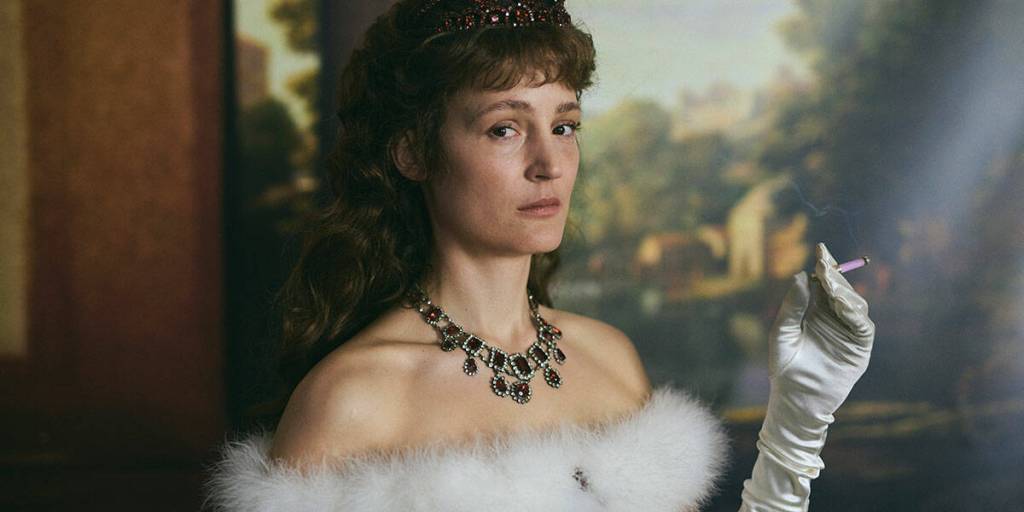 Corsage, a visually stunning contemporary waltz through the life of the extravagant Empress Elisabeth of Austria (Vicky Krieps), whose beauty and corsetry were famed in lands worldwide.