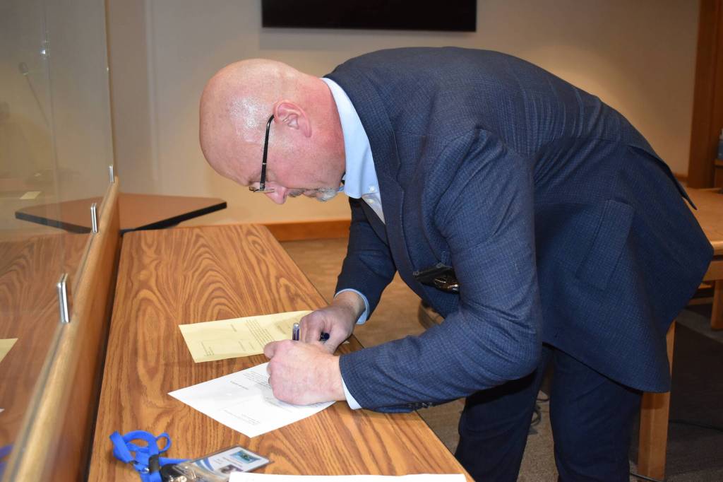 Kelley Balcomb-Bartok\ Staff photo
Newly Elected Sheriff Eric Peter signs official election paperwork during a ceremony Dec. 30 at the Superior Court courtroom.