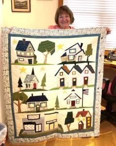 Karen Blinn displays her quilt, My Kind of Town, to be raffled at Emmanuels Blue Lamb Boutique Nov. 18.