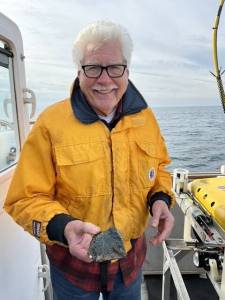 Adam Summers photo
Dr. H. Gary Greene holds a sample of vesicular basalt at the site of the Devils Mountain Volcano.