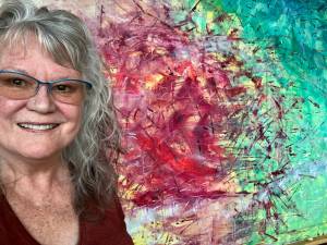 Amanda Azous in front of one of her paintings.