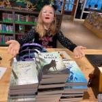 Larkin Remy with books to be given away to 3rd-grade students after the author signs copies.