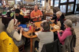 A group engages in needlework.
