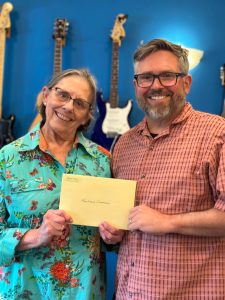 Marcia Spees of the Madrona Club presenting a check to Funhouse Executive Director Ryan Carpenter.