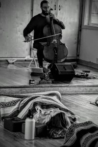 Artist in residence Harlen Silverman performing a meditation on cello in the Doe Bay yoga studio.