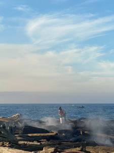 Contributed photo by San Juan Island Fire and Rescue
A Good Samaratine kayaker dousing smolding logs wiht buckets of water